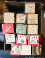 Front view of all 13 boxed rolls showing brands and some titles