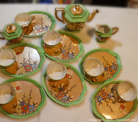 Full set laid out showing teapot, sugar bowl, creamer, plates and cups