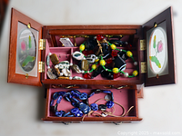 Open jewelry box showing upper compartment with assorted jewelry