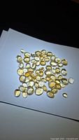 Spread of numerous golden citrine cabochons on white background