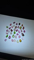 Group of multicolour leaf-cut tourmaline stones on white background