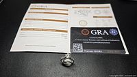Ring, grading report booklet and warranty card displayed