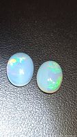 Two opal cabochons on black background