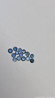 Group of small round blue sapphires on neutral background