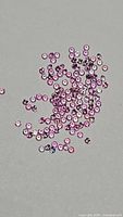 Group of small round pink sapphires on grey background