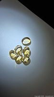 Six oval golden citrine cabochons displayed on white surface