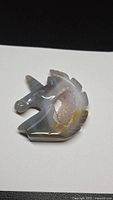 Front view of agate unicorn carving showing druzy cavity