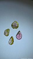 Four carved bicolour watermelon tourmaline gemstones on white background