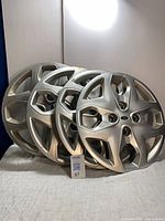Three of the four hubcaps stacked showing overall style and finish