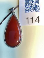 Front view of teardrop carnelian pendant beside lot identifier