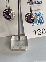 Full view of both sterling silver amethyst earrings on stand