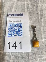 Pendant beside auction card showing size