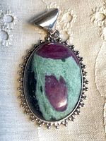 Front view of pendant showing stone, frame, bail