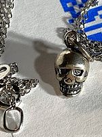 Close-up of sterling silver skull pendant and chain links