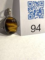 Front view of sterling silver tiger’s-eye pendant with bail