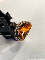 Angle view of tiger eye cabochon in silver setting