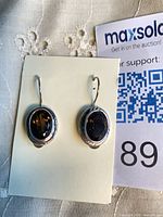 Front view of earrings showing faceted smoky quartz stones and sterling bezel