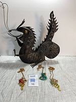 Overall lot showing metal dragon tealight holder and three necklaces