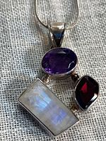 Close-up of pendant with three gemstones and bail