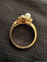 Ring side view showing gold-tone shank and twin pearl setting