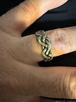 Ring on finger showing braided design