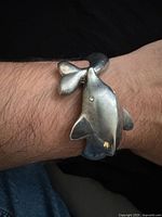 Bracelet worn on wrist showing whale head and tail design