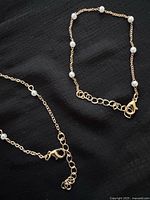 Both gold-tone bracelets showing clasps and extender chains