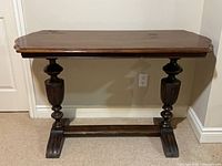 Front view of walnut console table showing top and legs