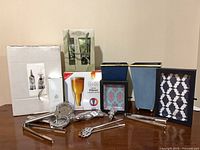 Entire lot showing boxed glasses, bottle gift set, decorative frames, blue containers and stainless tools