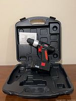 Drill standing in open case showing interior compartments