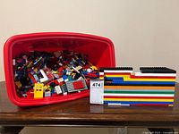 Overall lot with red bin of LEGO parts and assembled wall section