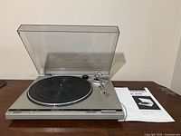Front view of Technics SL-B200 turntable with dust cover and manual