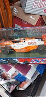 Boxed 1:18 scale Maisto IRL IndyCar #22 viewed through front window