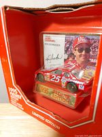 Front view of sealed boxed diecast showing car, driver card, Premier Edition plaque