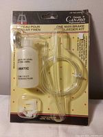 Front view of sealed Can-Pro one-man brake bleeder kit showing bottle, hose, fittings