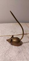 Side view of brass mouse with long tail.