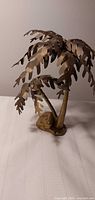 Full view of brass palm tree sculpture showing dual trunks, fronds, base