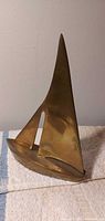 Full view of brass sailboat sculpture standing upright