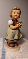 Front view of Hummel figurine showing girl with bouquet