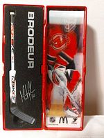 Closed display case showing stick and Brodeur photo
