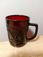 Front view of ruby red pressed glass mug