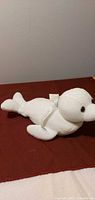 Full side view of white seal plush on surface