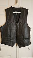 Front view of black leather vest on hanger