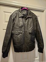 Full view of jacket on hanger showing front, sleeves, knit waistband