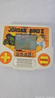 Front view showing screen, controls, Jordan vs Bird artwork