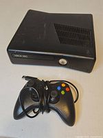 Front angled view of Xbox 360 console and wired controller