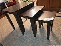 Three nesting tables stacked side-by-side showing size gradient and leg design