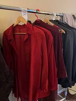 Rack with burgundy suede coat and additional garments