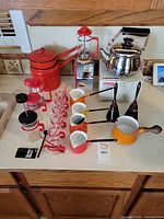 Full collection showing kettle, double boiler, French presses, glass cups, enamel pots
