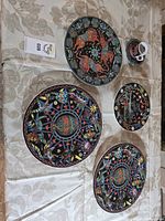 Full set: five plates and mug displayed